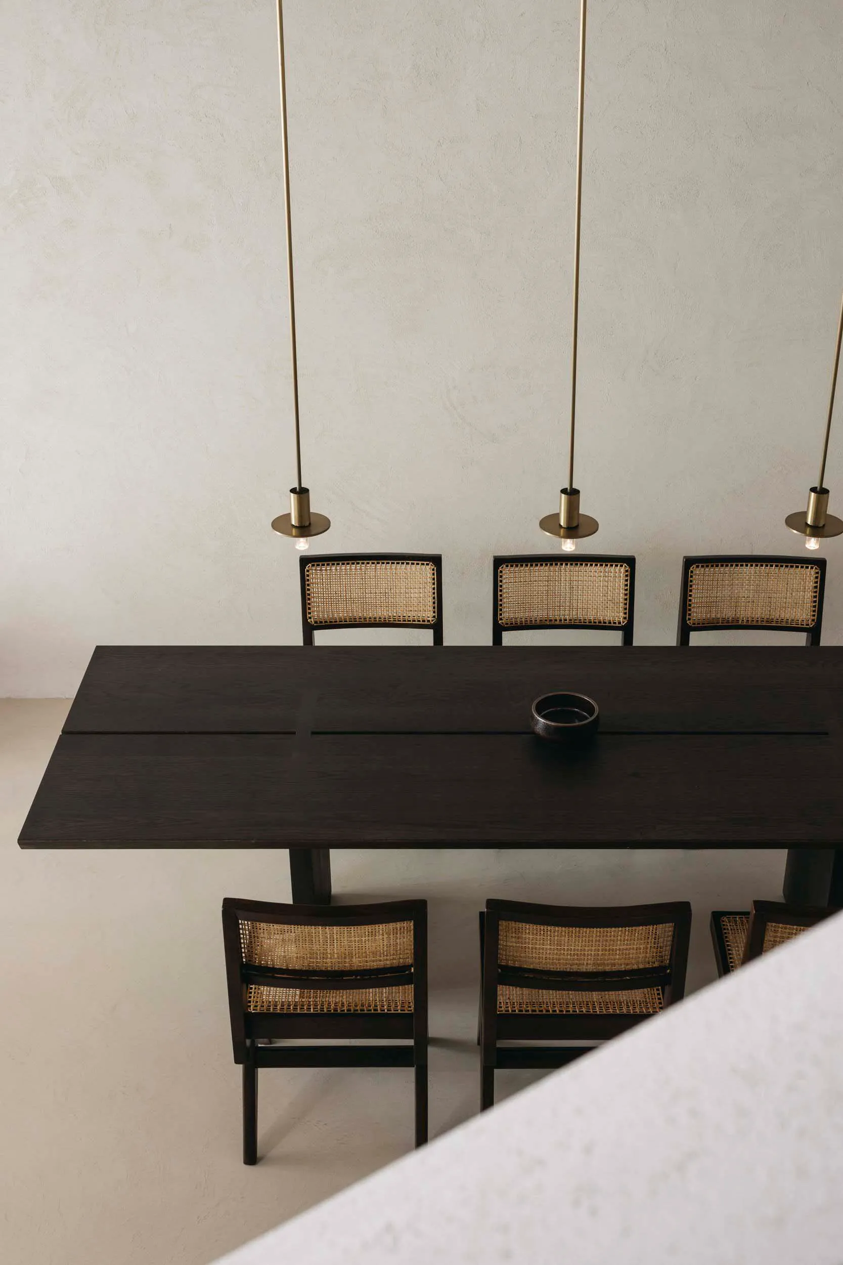 A modern dining room with a wooden table and chairs, minimalistic design and geometric shapes.