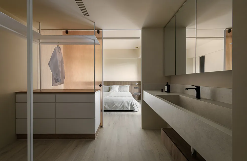 Modern minimalist bedroom featuring white concrete and lighting fixtures.