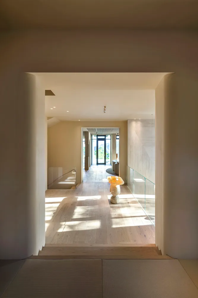 Modern entryway featuring wood flooring and concrete walls.