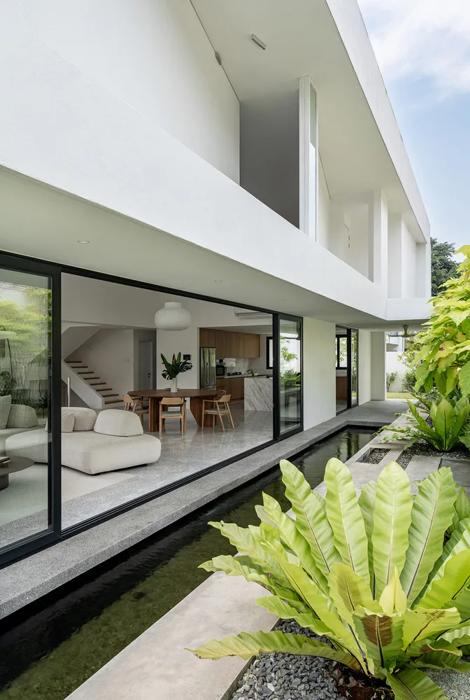 A minimalist modern interior with large glass windows and concrete surfaces.