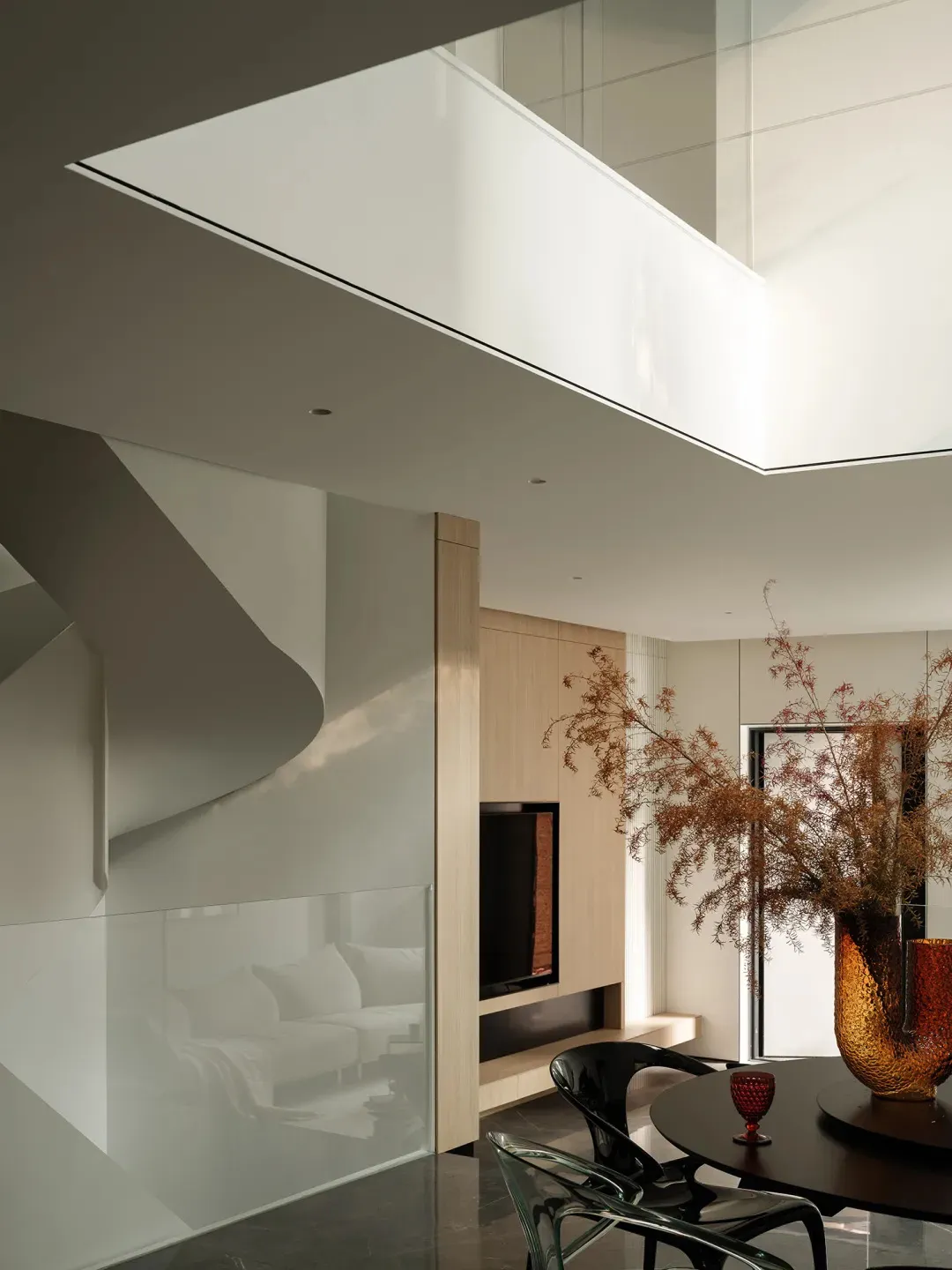 Modern interior featuring a glass staircase and minimalist design elements.