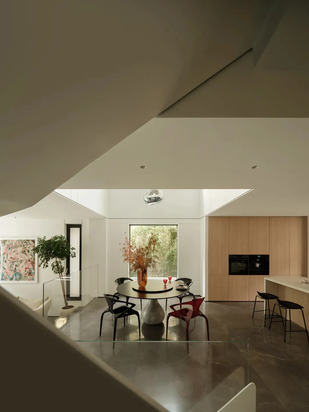 A modern kitchen with marble countertops, glass decor, and botanical elements.