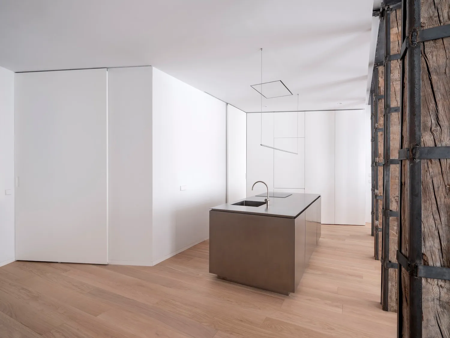 A modern kitchen featuring a minimalist design with a steel countertop.