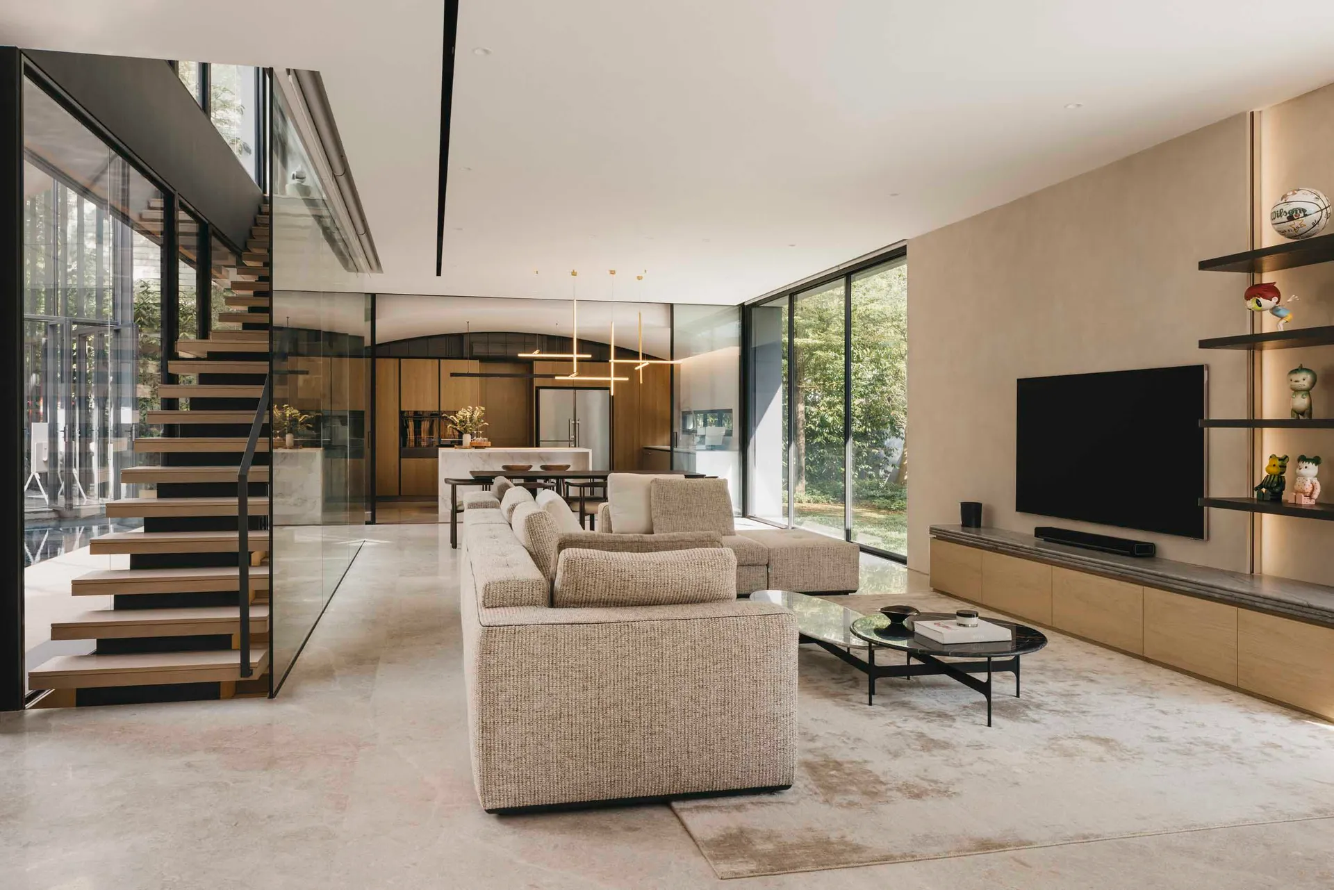 A modern minimalist living room features glass walls, wooden flooring, and marble accents.