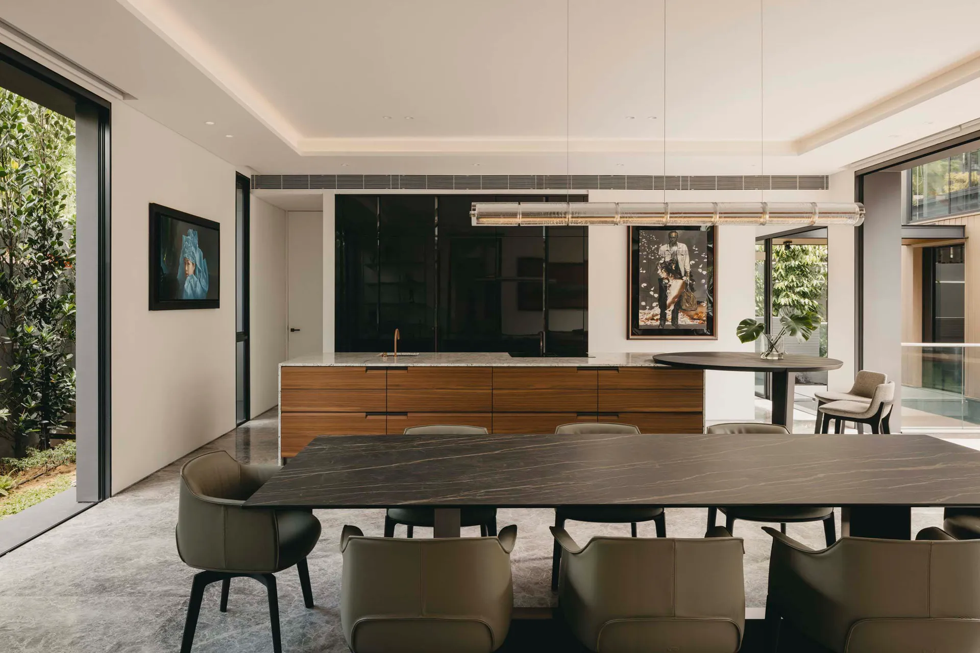 Modern residential interior featuring an open-plan living, dining, and kitchen area with marble countertops, wooden cabinets,