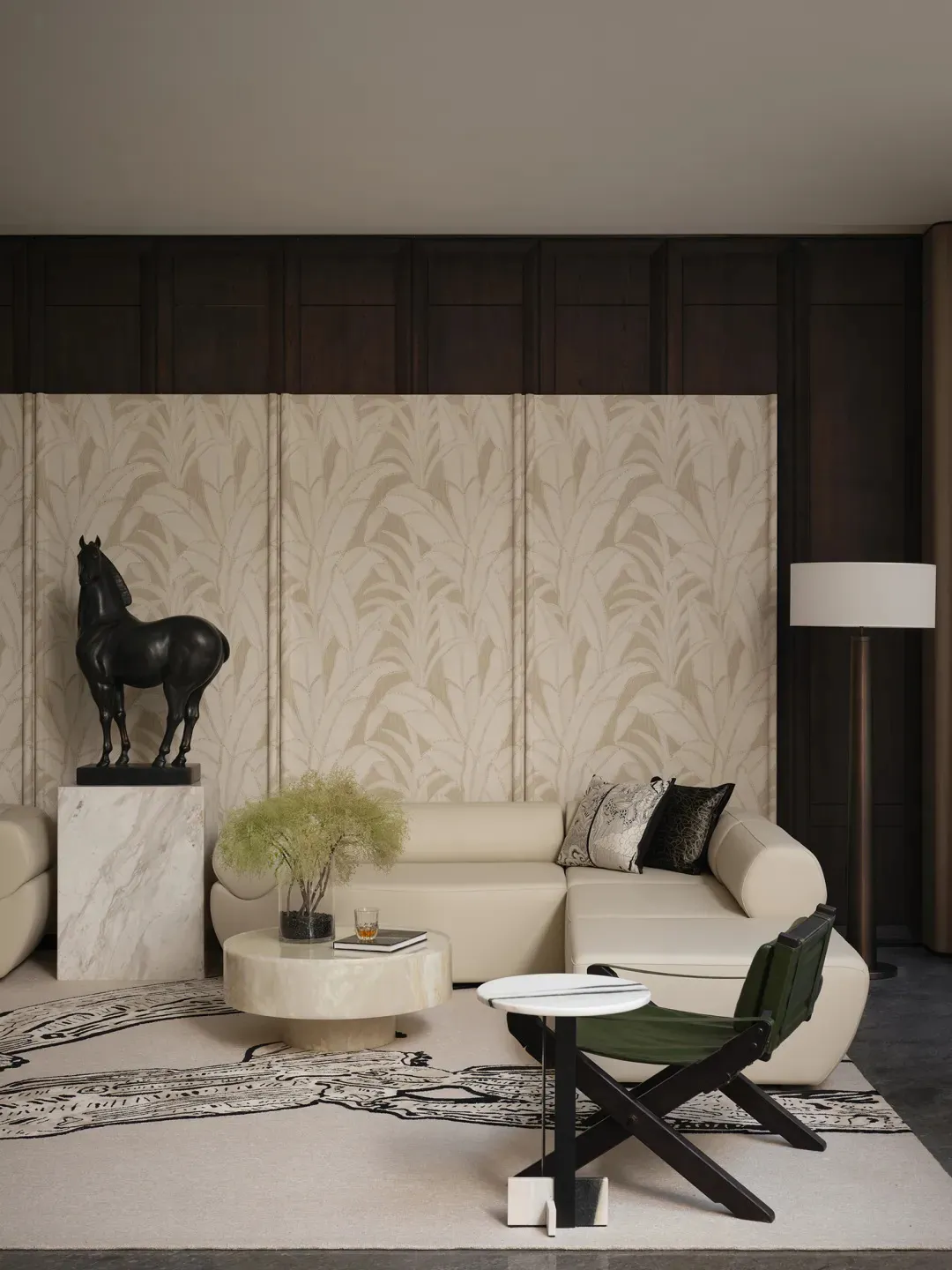 A modern living room featuring a white leather sofa, marble coffee table, and dark wood accents. A black horse sculpture stan