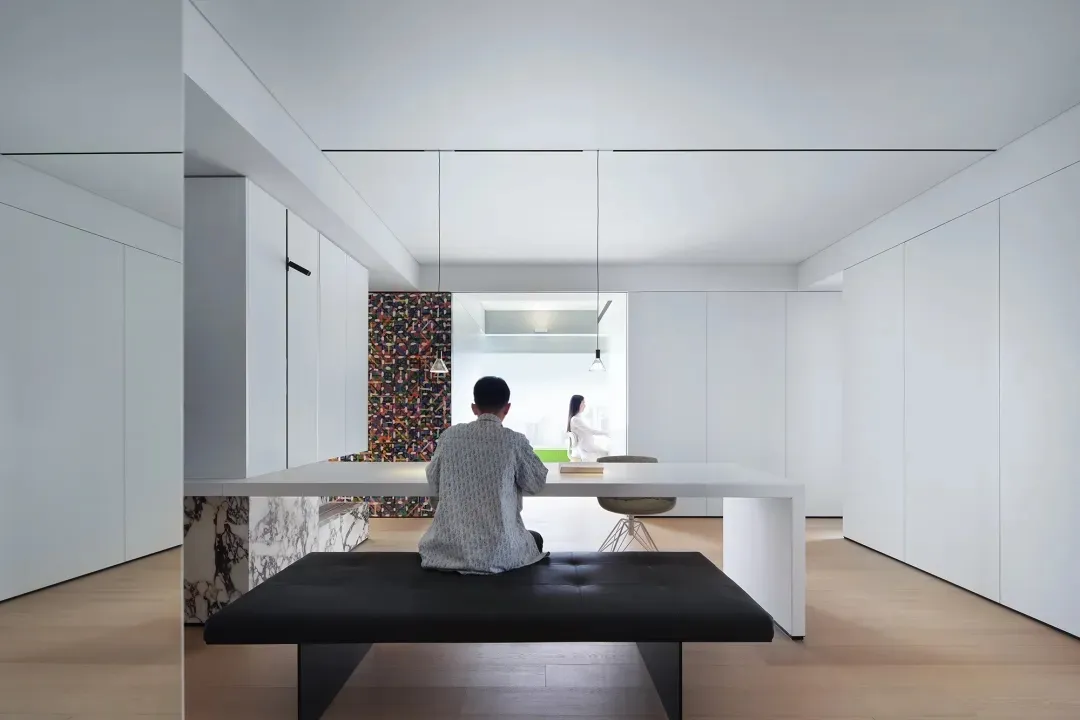 A modern living room with white furniture and minimalist design.
