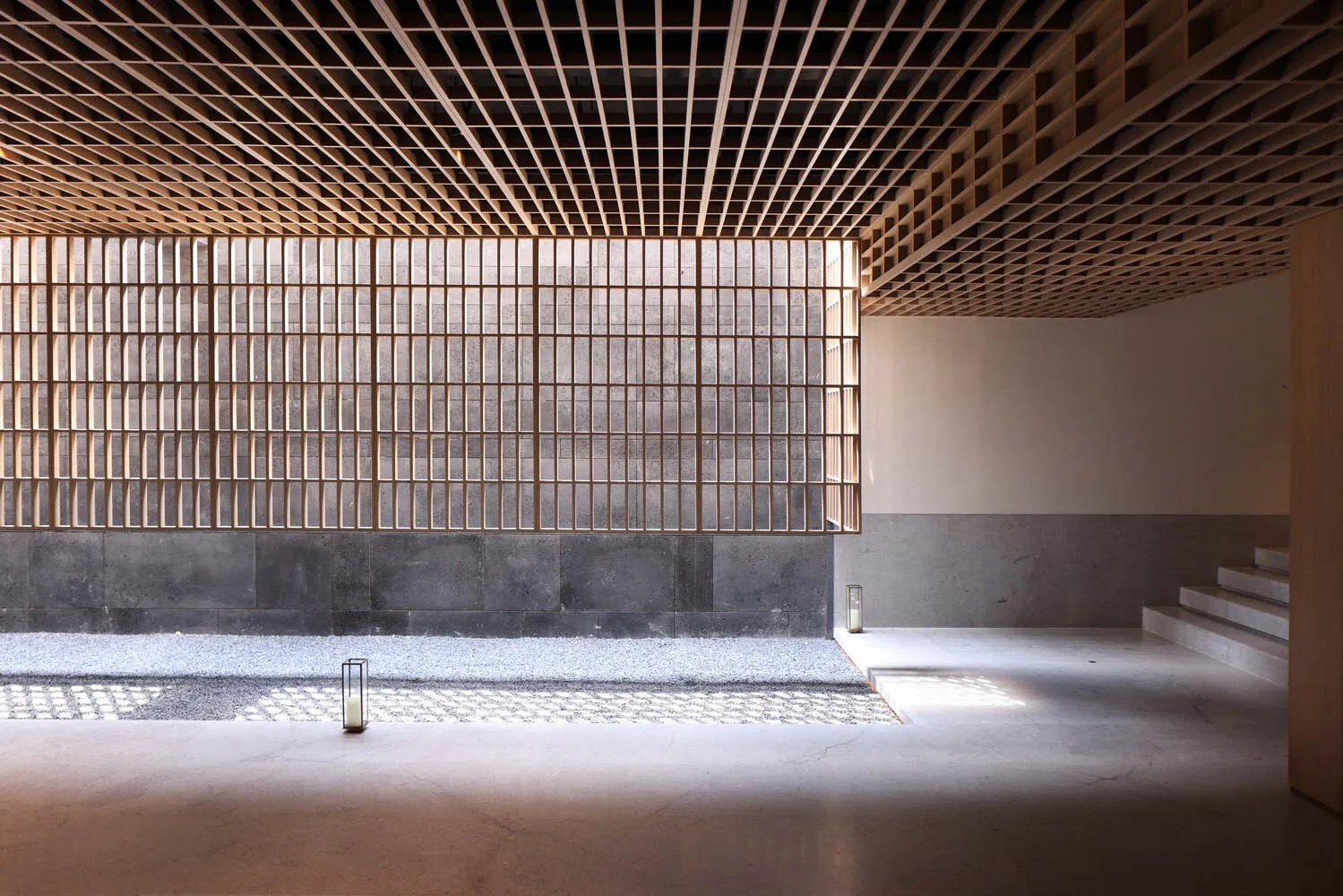 A minimalist interior design featuring wooden ceiling beams and concrete walls.