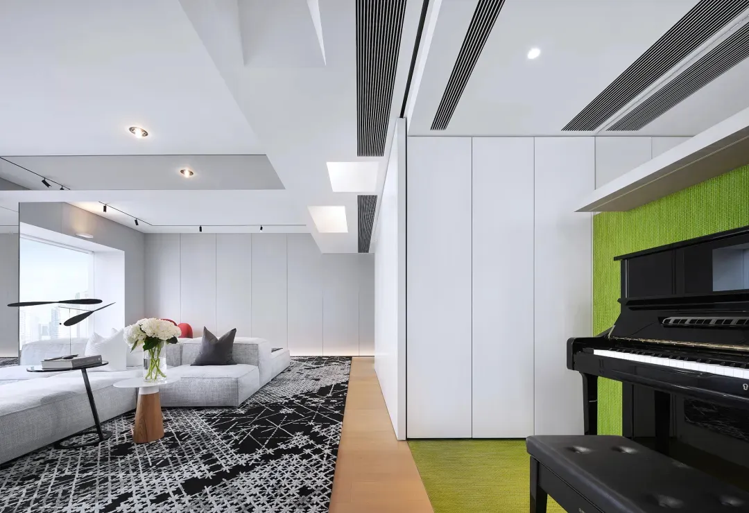 簡約客廳擺放白色與灰色家具，並點綴綠色植栽。