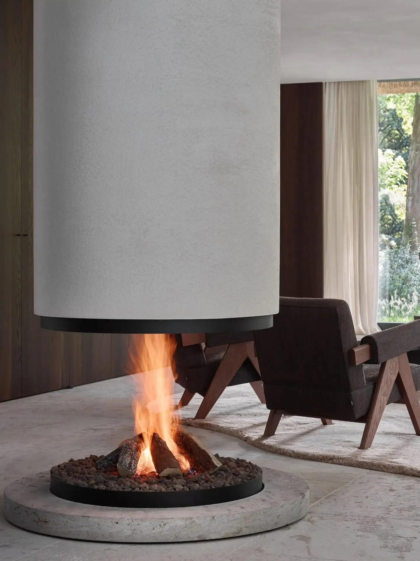 A modern living room with a circular concrete fireplace, wooden furniture, and a view of greenery outside.