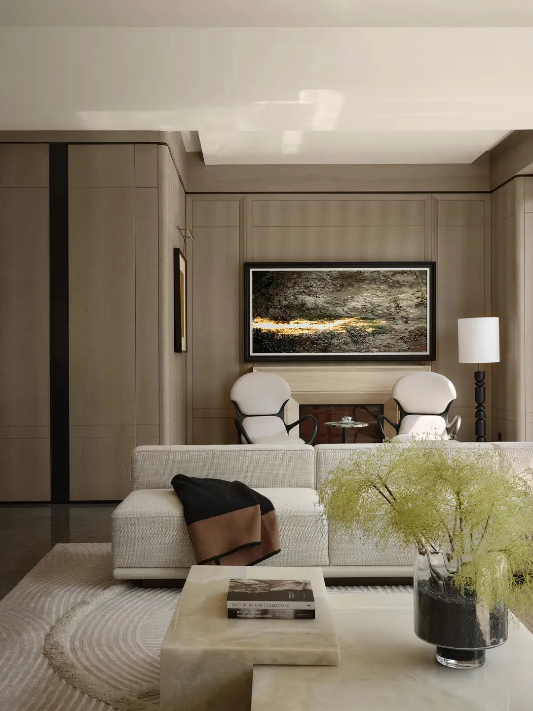 Modern living room with white and beige tones, featuring a minimalist white couch, white chairs, a marble coffee table, and a