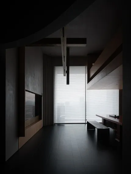 A minimalist interior design featuring concrete walls and large glass windows.