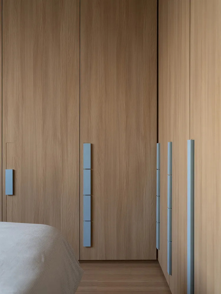 A modern minimalist bedroom featuring wooden furniture and paneling.