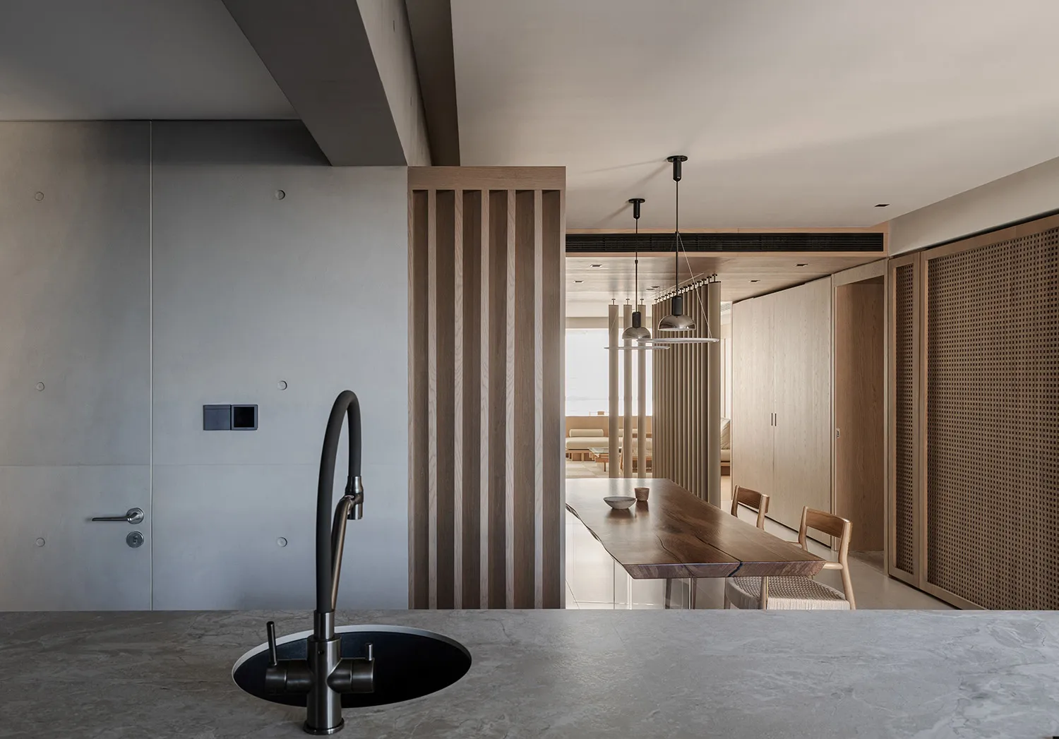 A modern residential kitchen features a concrete countertop and wooden cabinets.