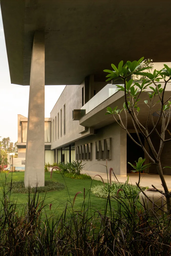 Modern house with concrete exterior and green landscaping.