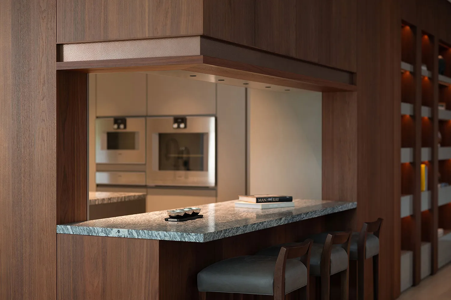 Modern kitchen featuring a marble bar counter with stools and a sleek interior design.