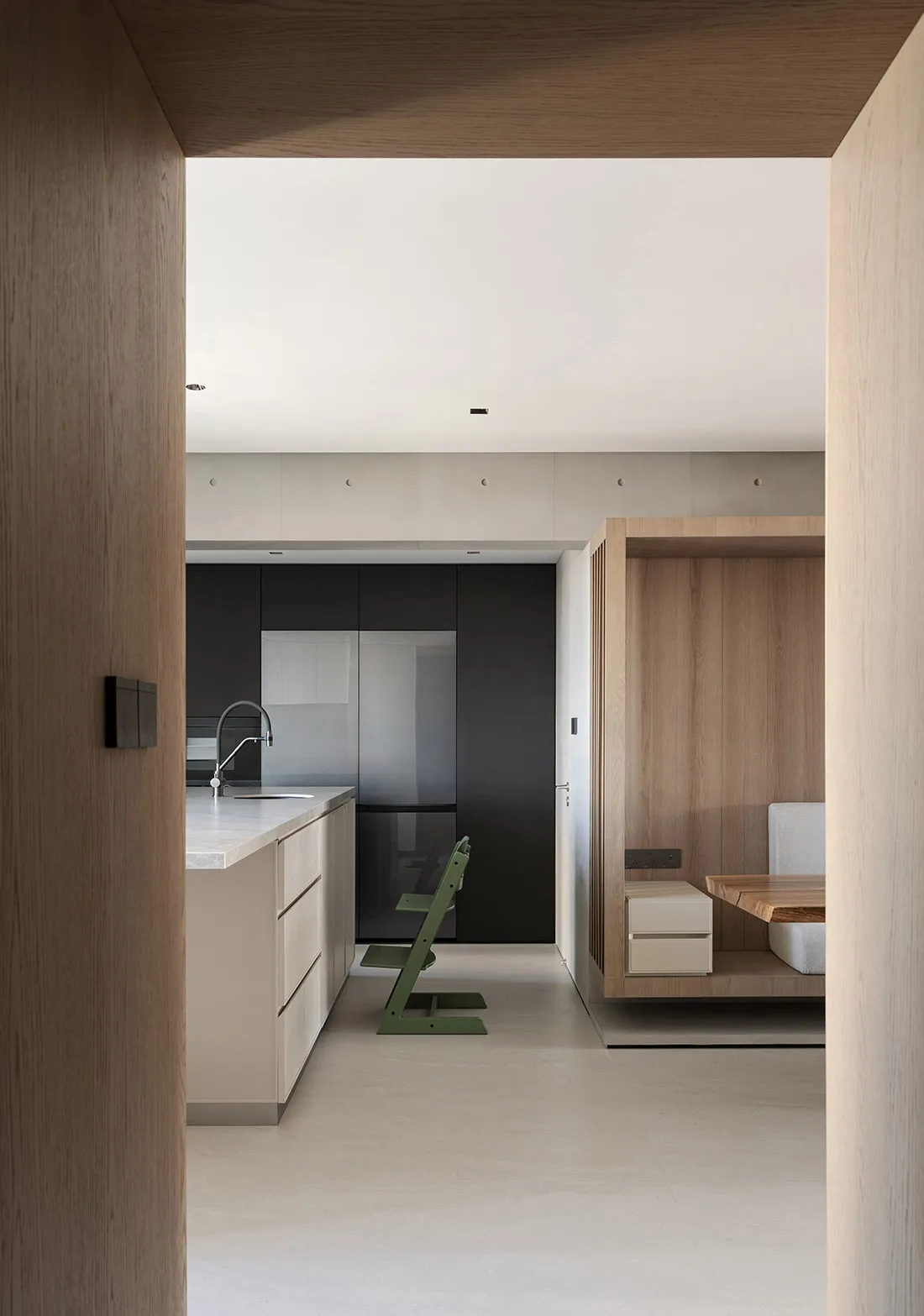A modern kitchen with minimalist design featuring neutral-toned materials and sleek cabinetry.