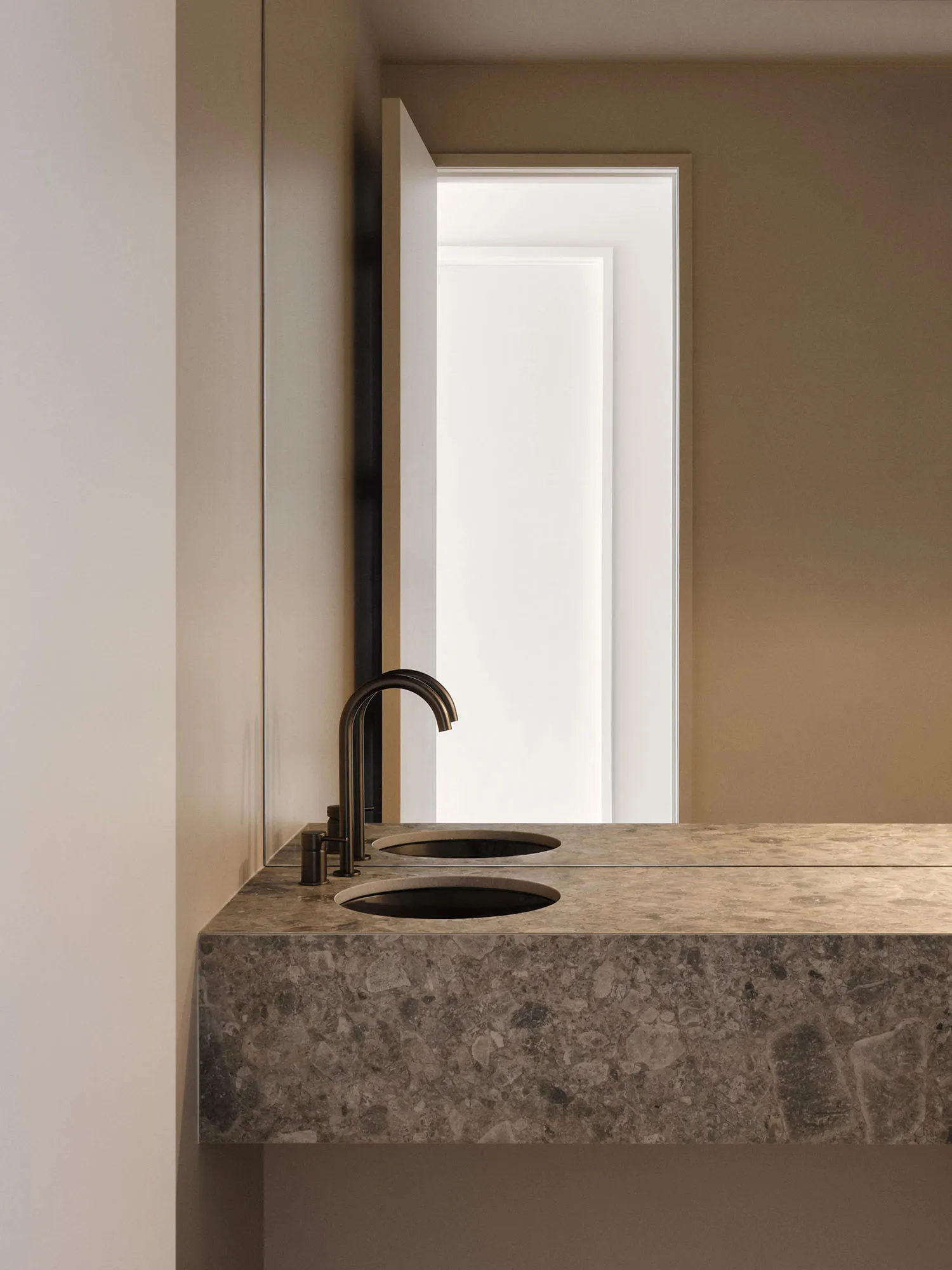 A minimalist bathroom featuring a modern marble countertop with two sinks and a sleek faucet.