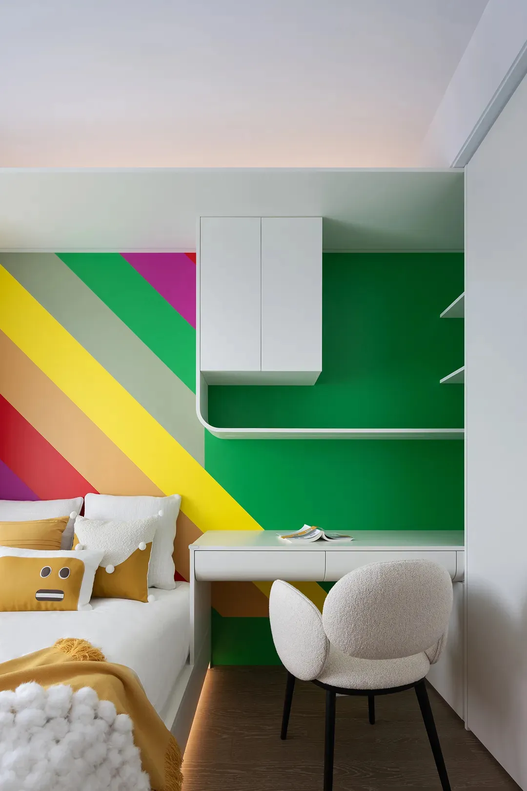 A minimalist bedroom with colorful stripes on the wall, white furniture, and a white chair.