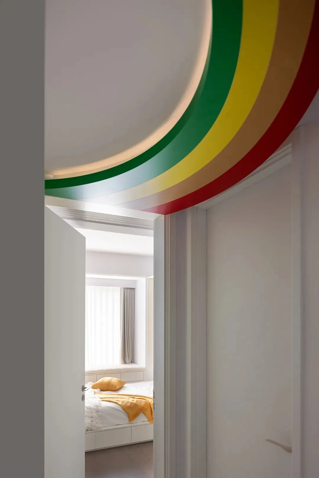 Minimalist bedroom featuring colorful decorative trims on the ceiling.