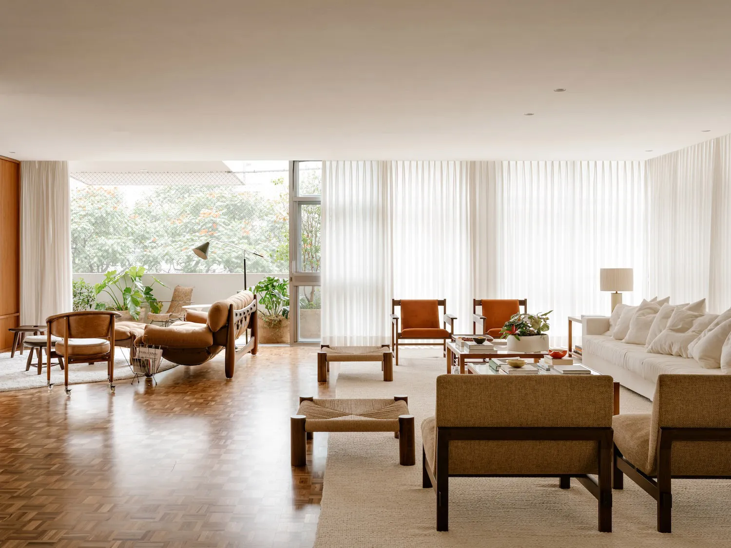 Modern minimalist living room featuring walnut furniture, glass windows, and neutral color palette.