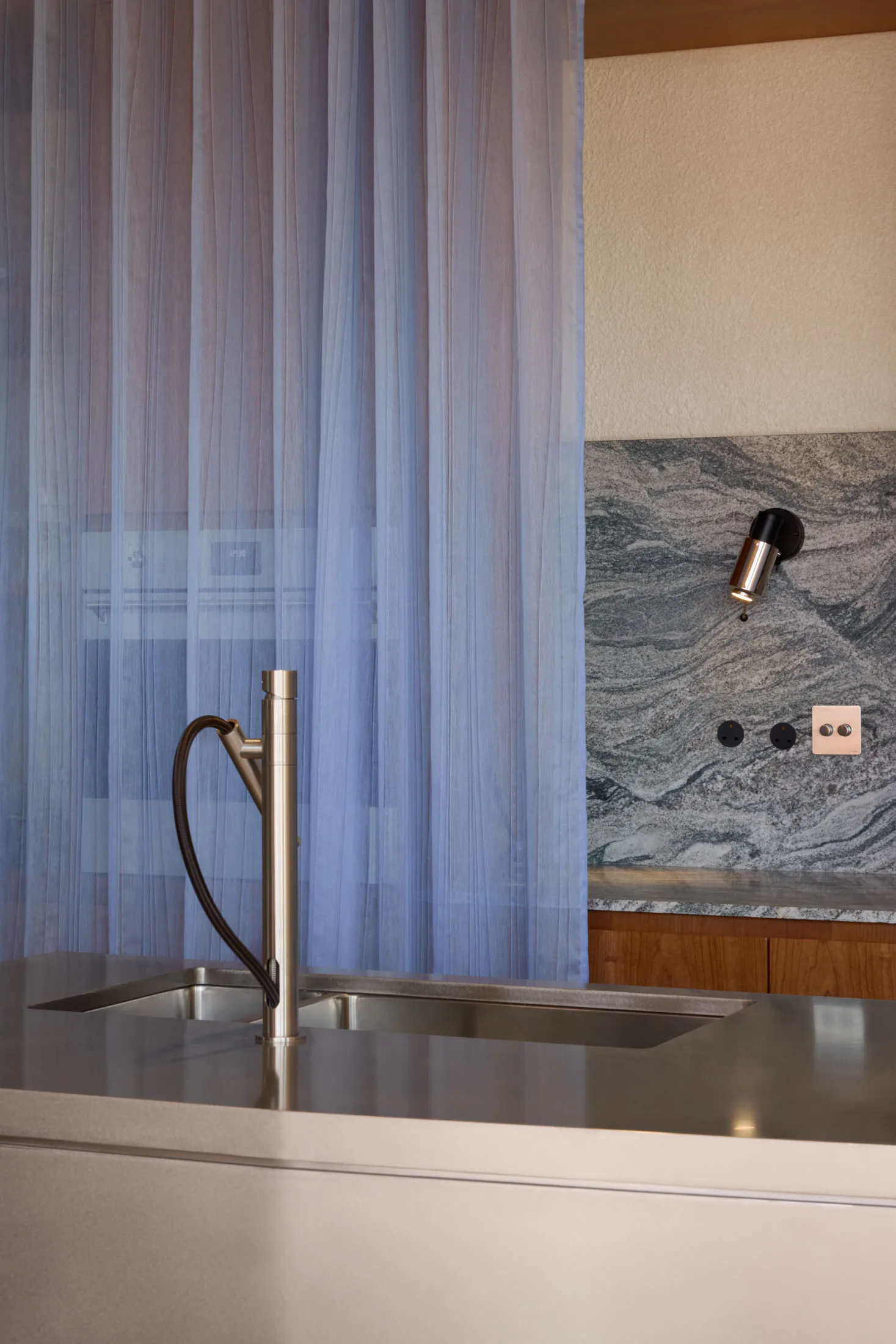Modern kitchen featuring stainless steel appliances, granite countertops, and a table lamp.