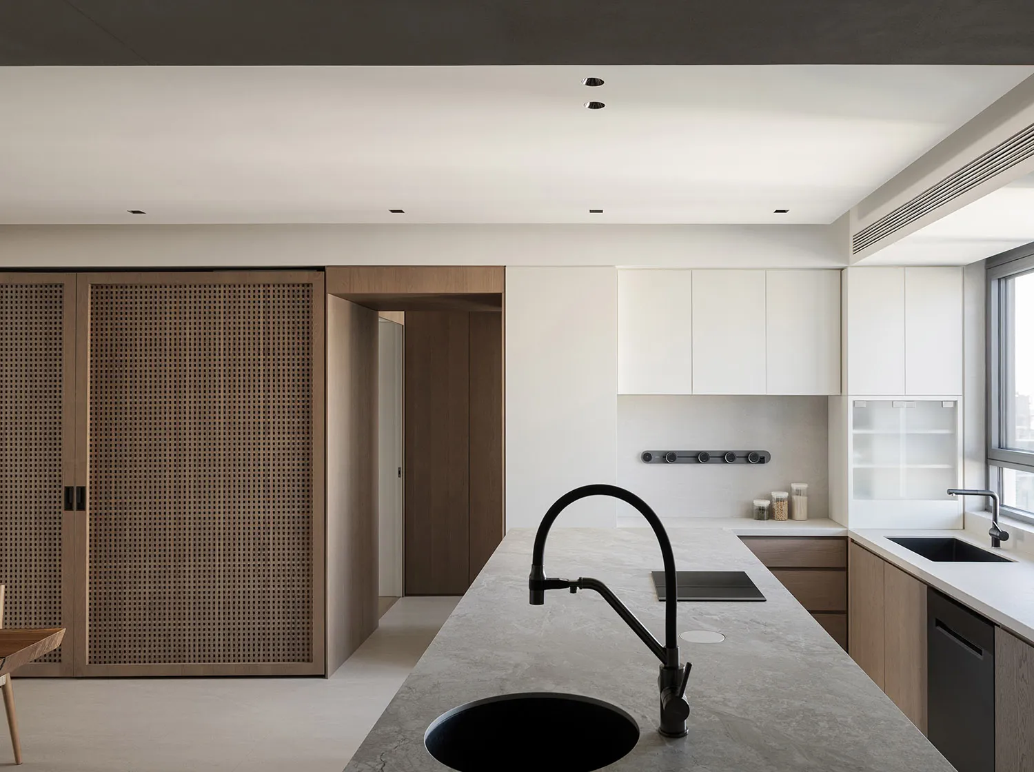 Modern minimalist kitchen featuring concrete, marble, and wood materials.