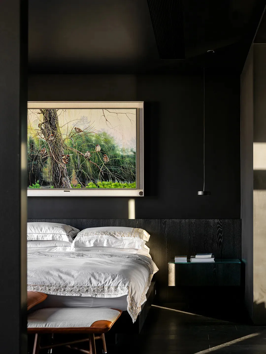 Modern minimalist bedroom featuring a wooden bed frame and steel nightstand.