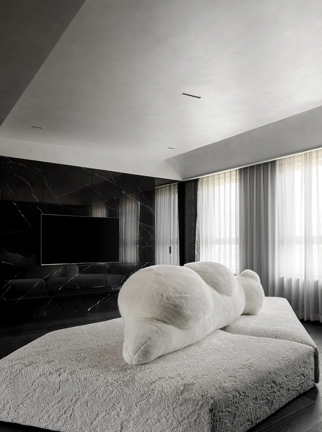 A minimalist living room with textured fabrics and marble accents.