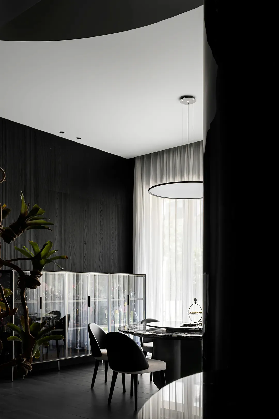 Modern minimalist dining room featuring glass, marble, and metal elements.