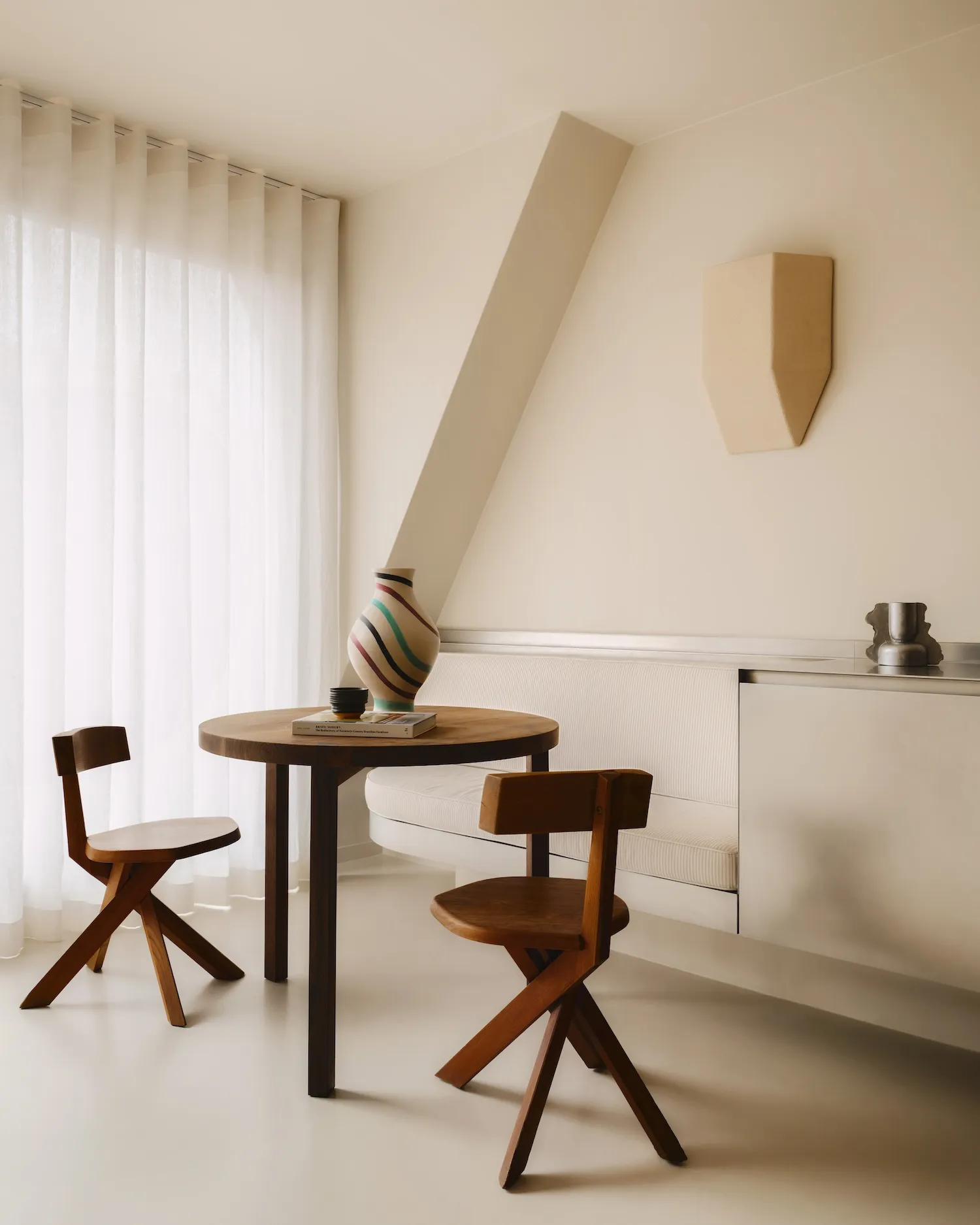 A minimalist living room featuring wood furniture, metal accents, and fabric seating.