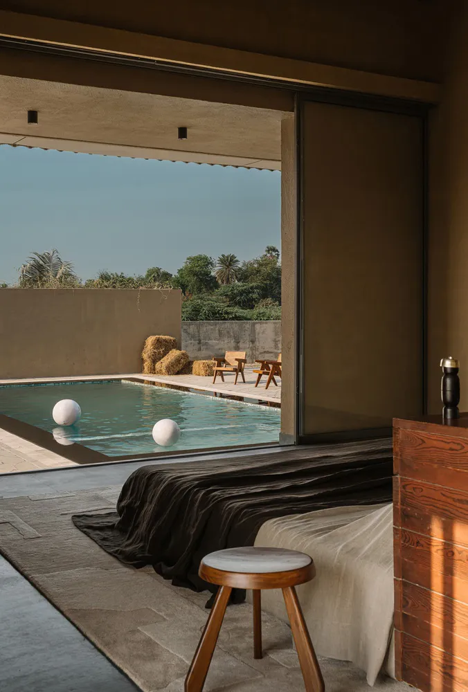 Concrete exterior of a residential building with a swimming pool and natural surroundings.