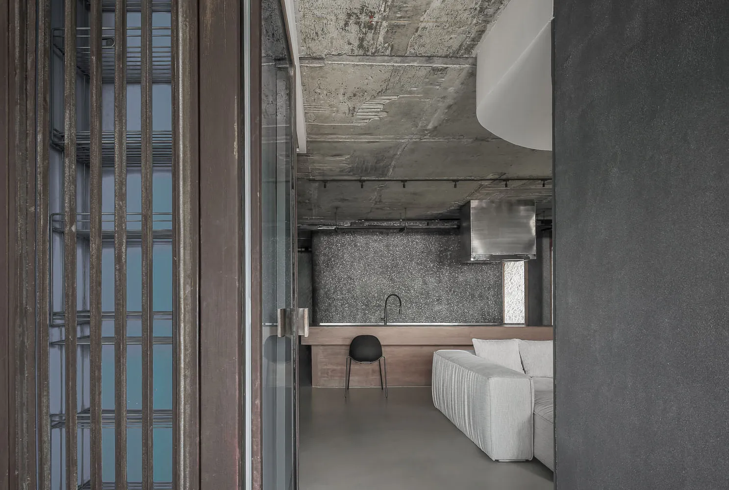 Modern industrial residential kitchen featuring concrete and glass materials.