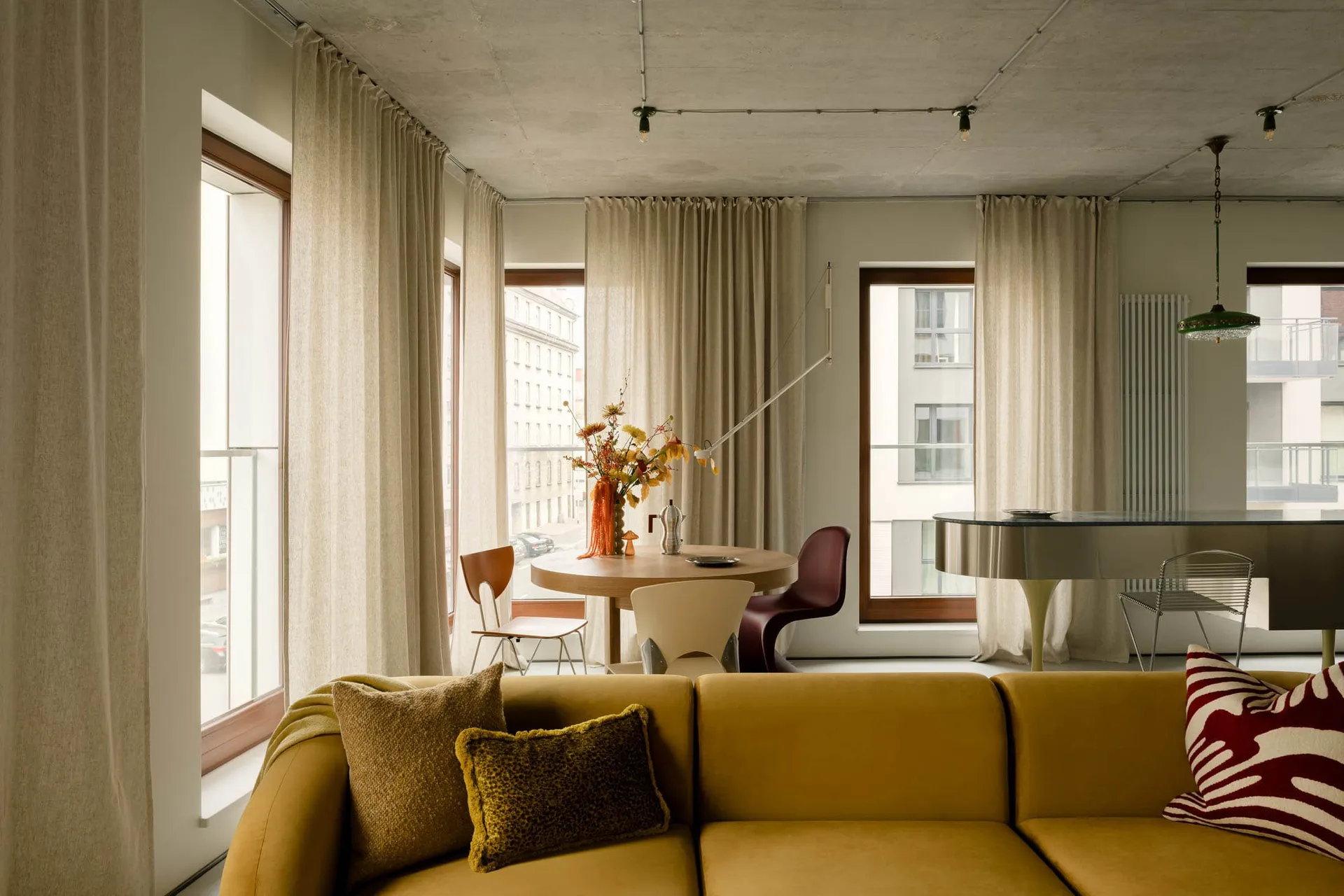 Modern living room with fabric furniture, concrete ceiling, and lighting design