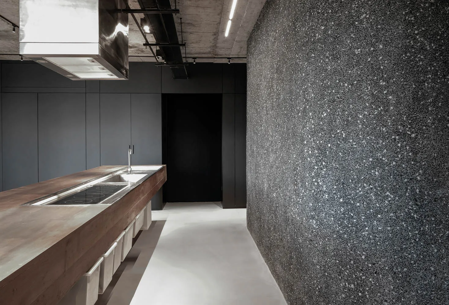 Modern minimalist kitchen with concrete countertop, featuring sleek, clean lines and a monochromatic color palette.