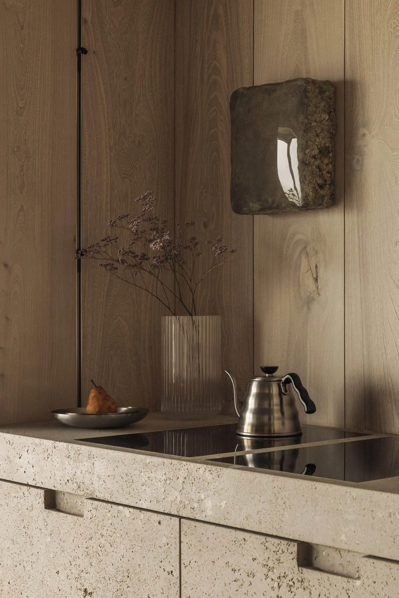 Minimalist kitchen featuring a concrete countertop and wooden cabinets.