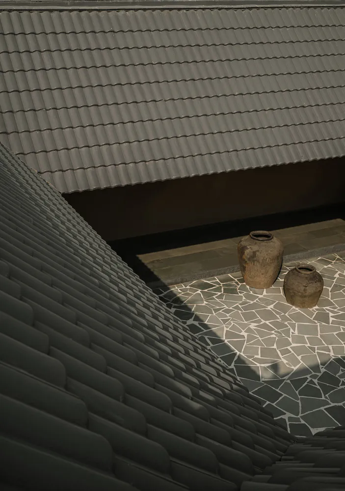 A terracotta roof with two pots on a mosaic tile floor.