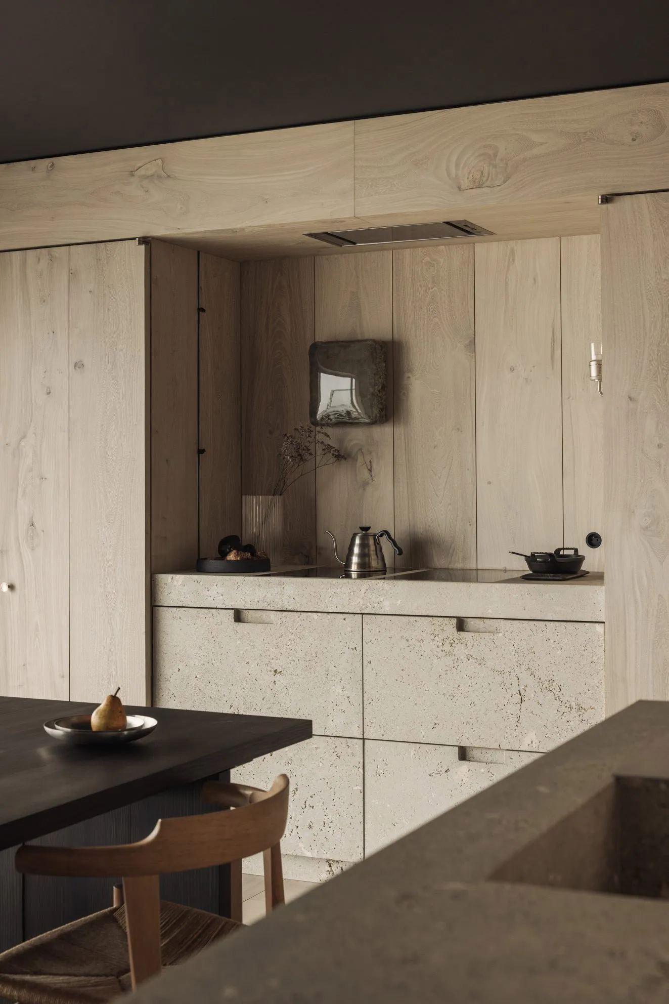 Minimalist kitchen with stone countertop and cabinets, featuring modern design elements.