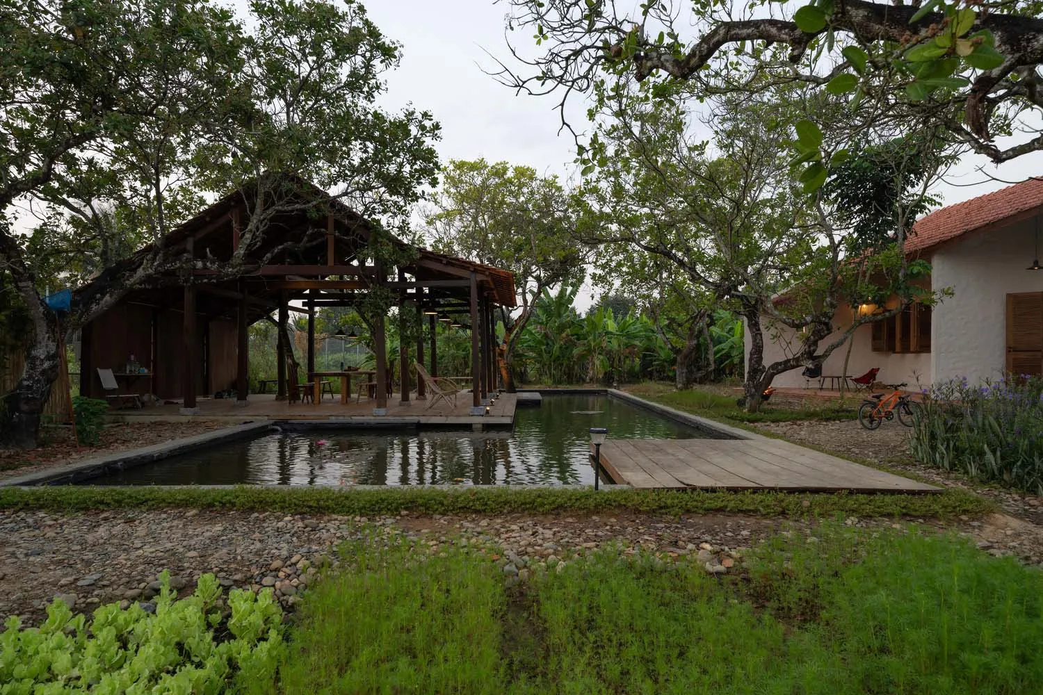 An outdoor spa area with a pool, wooden deck, and surrounding greenery