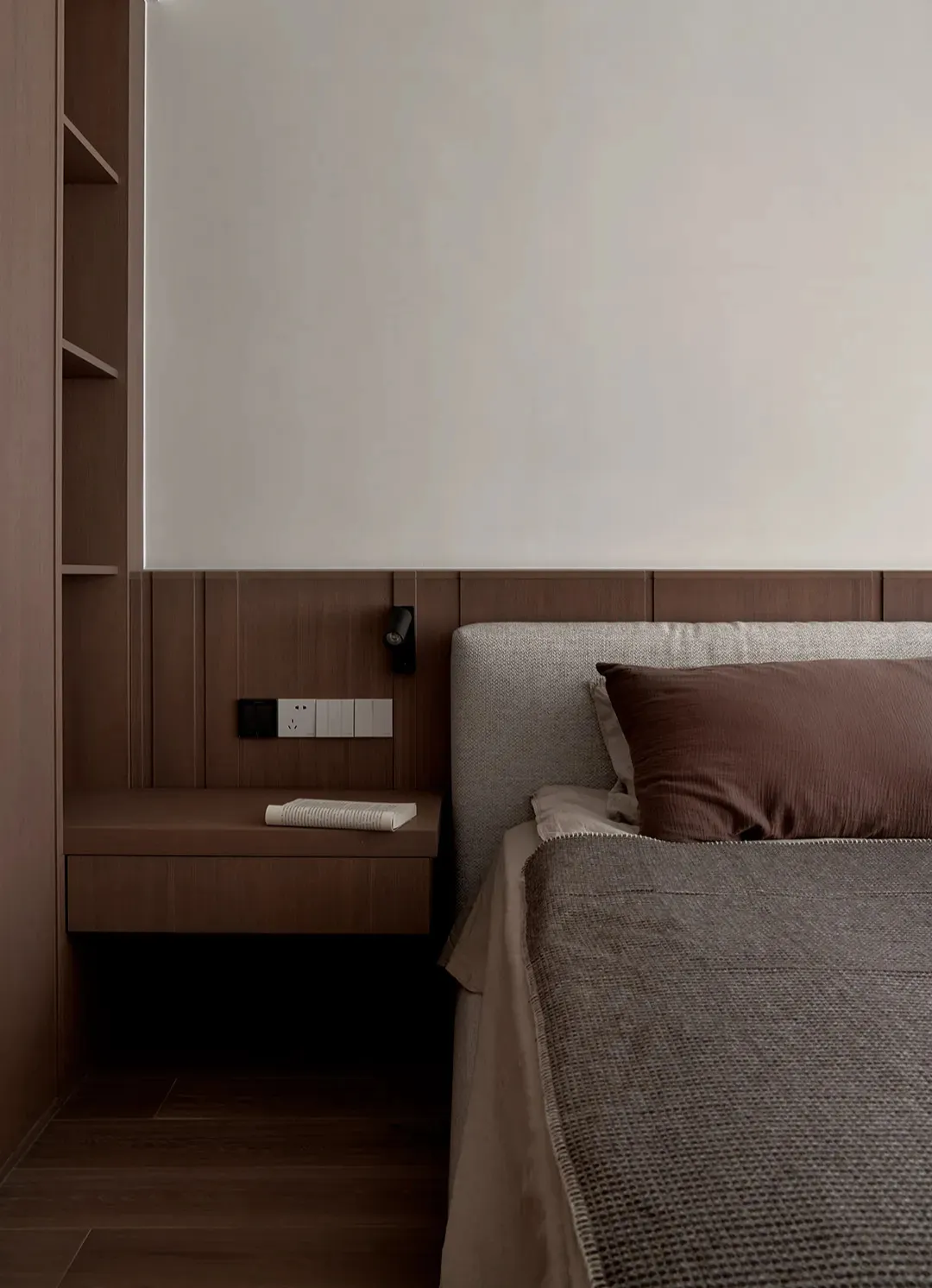 A minimalist bedroom featuring a wooden bed frame and headboard, with a simple and clean design.