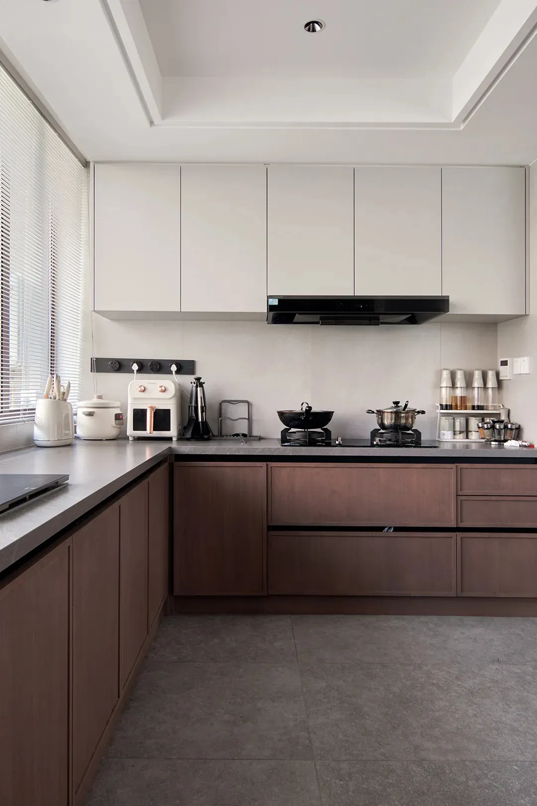Modern industrial kitchen with wooden cabinets and grey countertops.