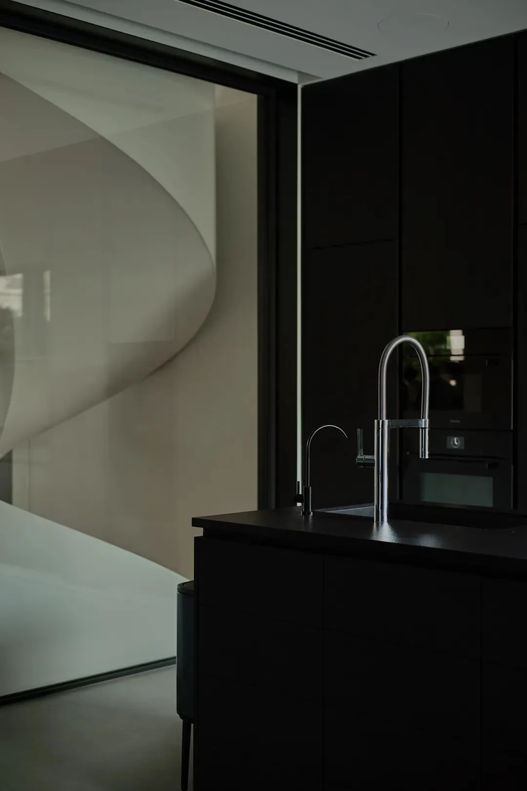 Modern kitchen with metallic fixtures and white wall