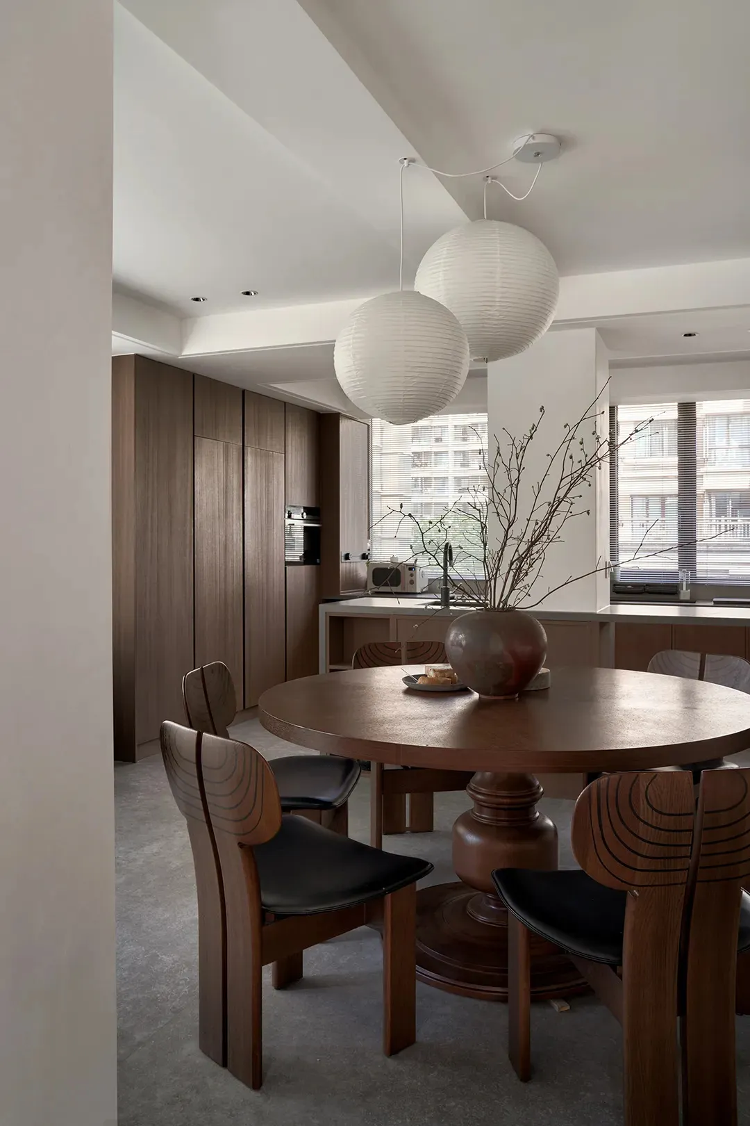 Modern kitchen with wooden furniture and a plant on the dining table.