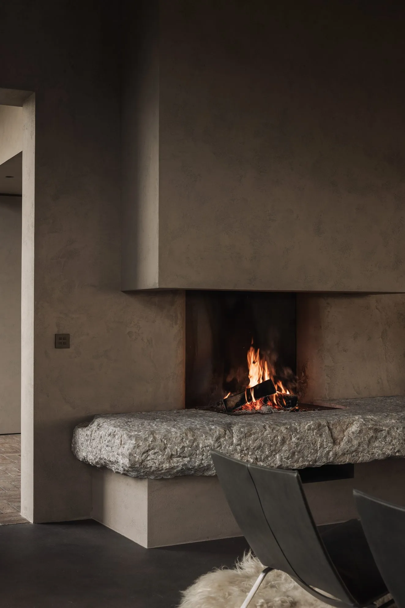 Modern interior design with a corner fireplace made of stone.