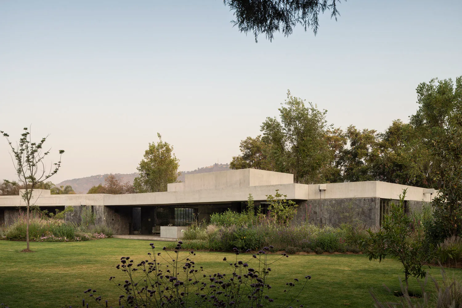 Modern residential building with concrete facade and landscaped garden.