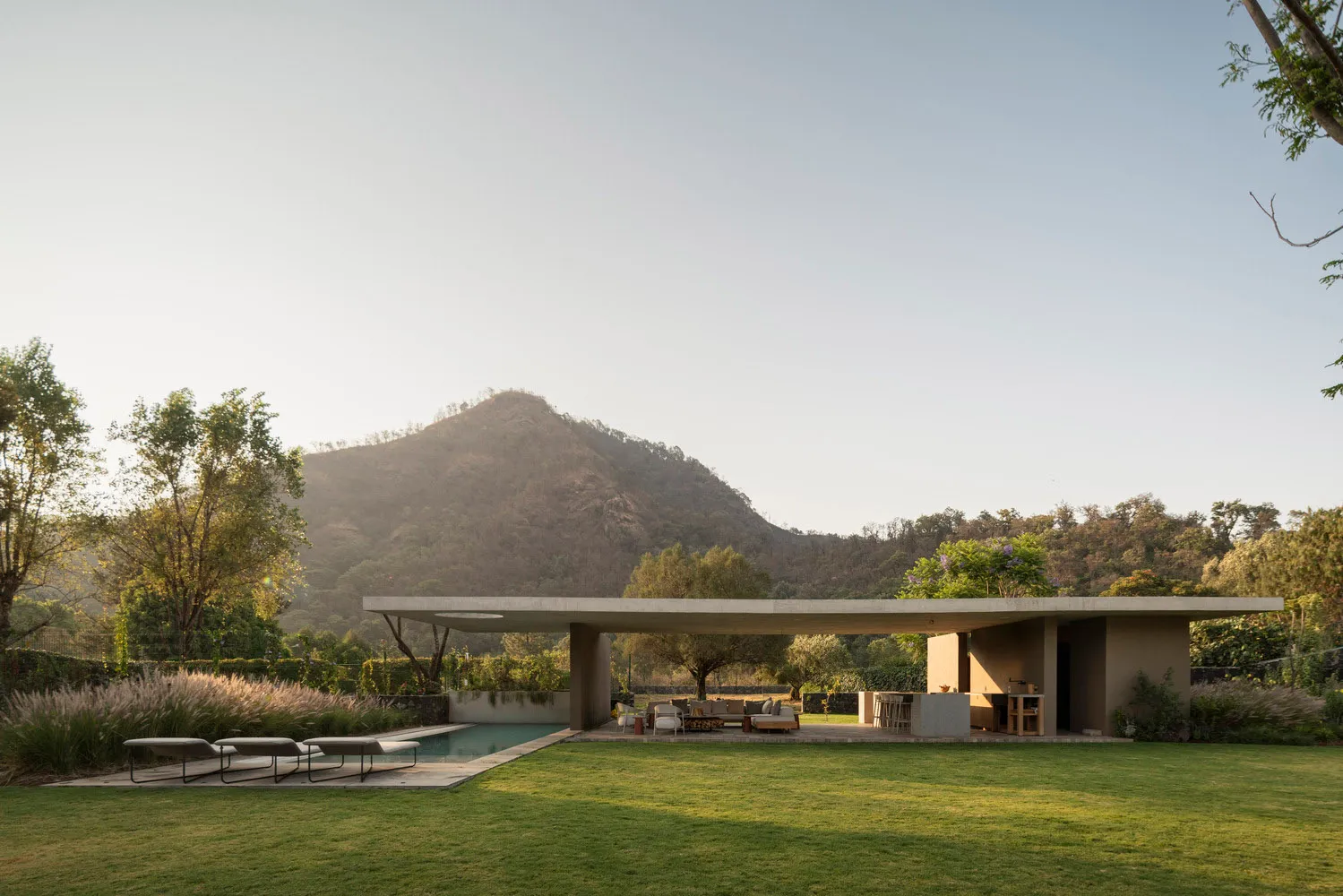 A modern house with a minimalist interior, featuring a concrete design and a view of the surrounding landscape.