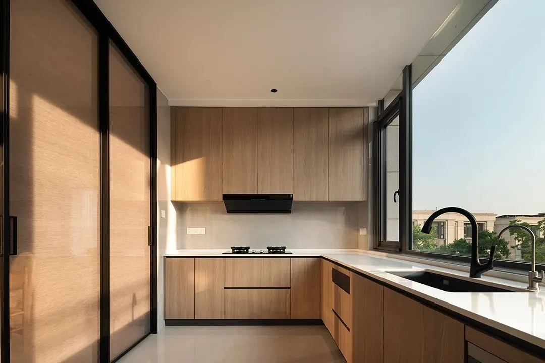 Modern kitchen featuring wooden cabinets and a glass window.