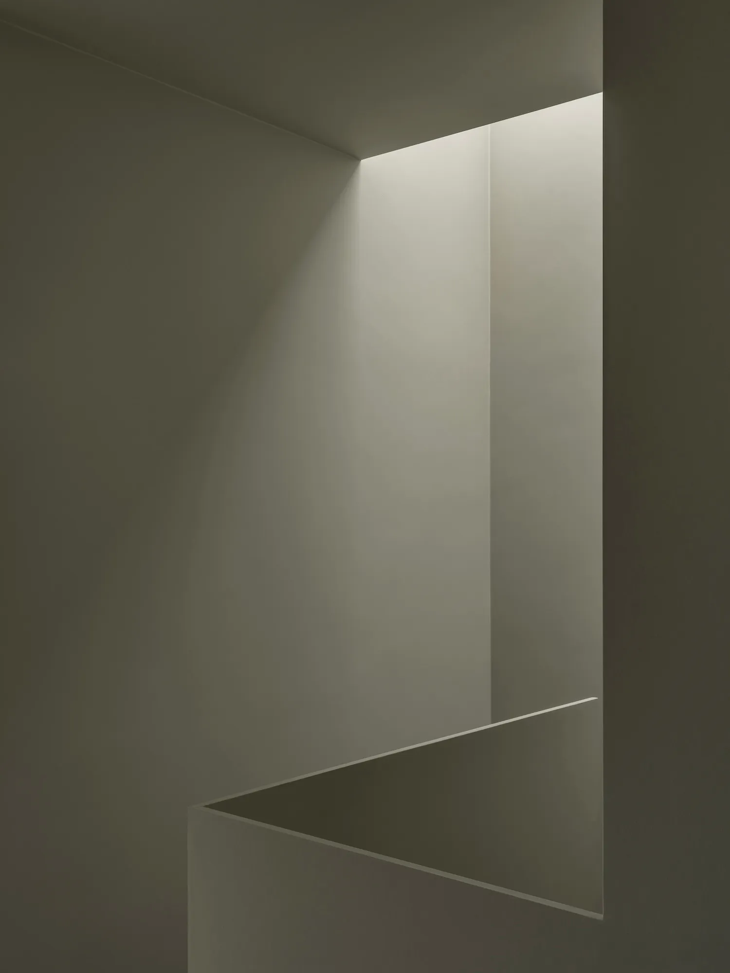 A minimalist interior space featuring concrete walls and flooring.