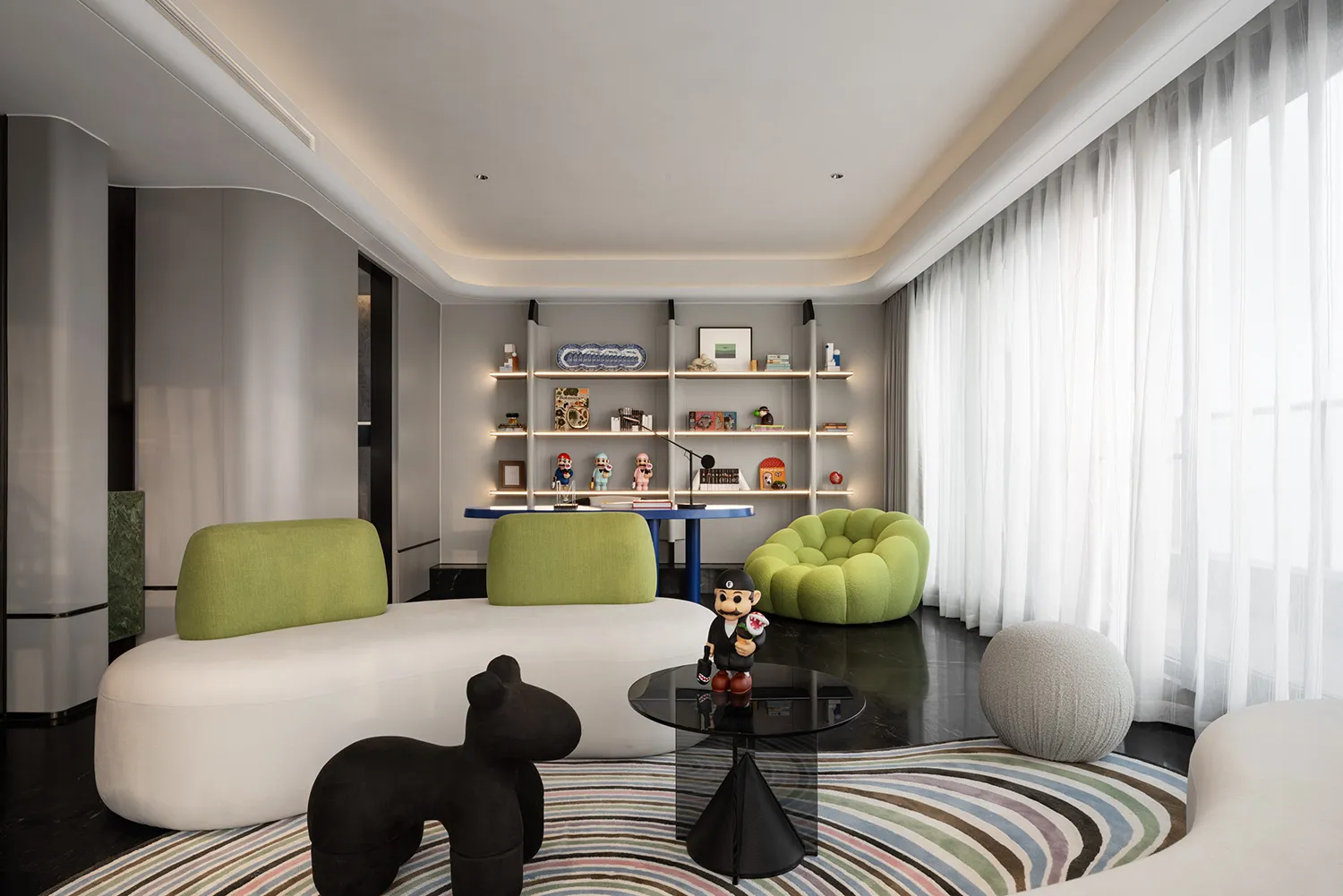A modern living room with a white sofa, green armchairs, and a black coffee table.