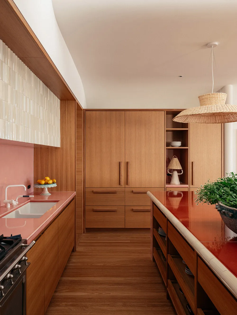 Modern kitchen featuring wooden cabinets and countertops with a vibrant pink backsplash.